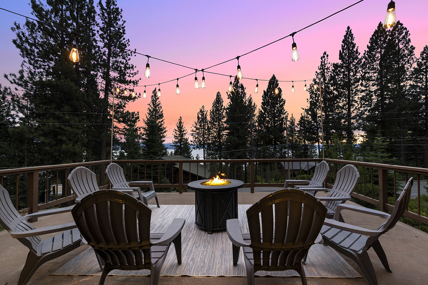 Adirondack chairs around the fire pit on the Kinpine House deck, Lake Tahoe glowing at sunset beyond