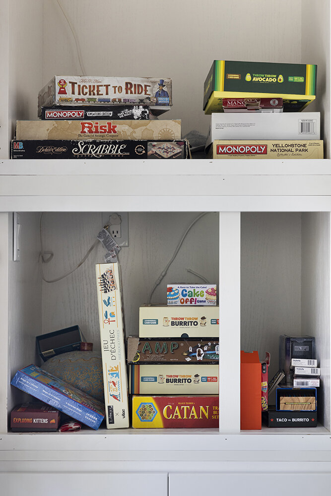 Shelf of board games including Catan and Ticket to Ride