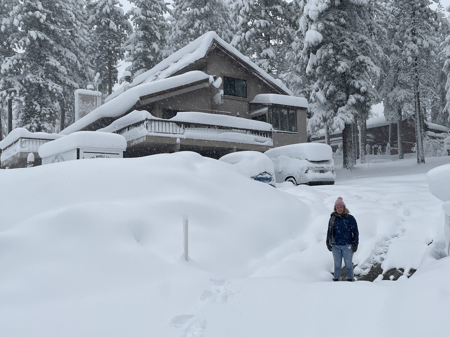 Kinpine House buried in fresh snow, cars covered in the driveway during a Tahoe storm