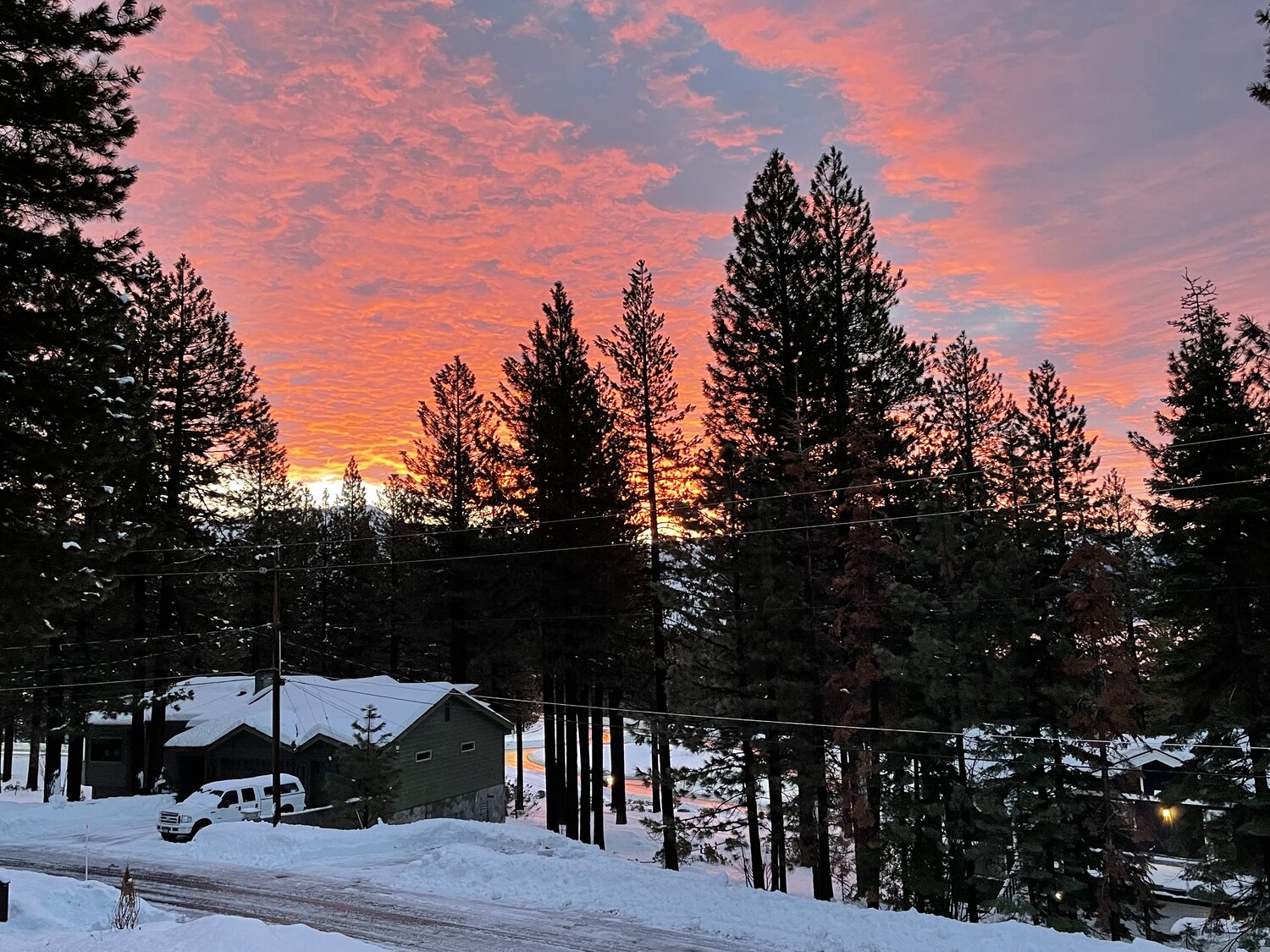 Winter sunset burning orange over snow-covered pines in Incline Village